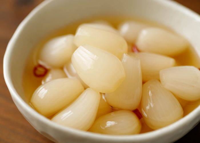 A bowl of pickled rakkyo (scallions), soaking in vinegar.